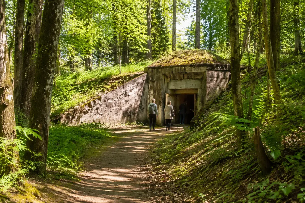 Travelers approaching the historic Secret Soviet Bunker entrance in the forest near Līgatne, Latvia.