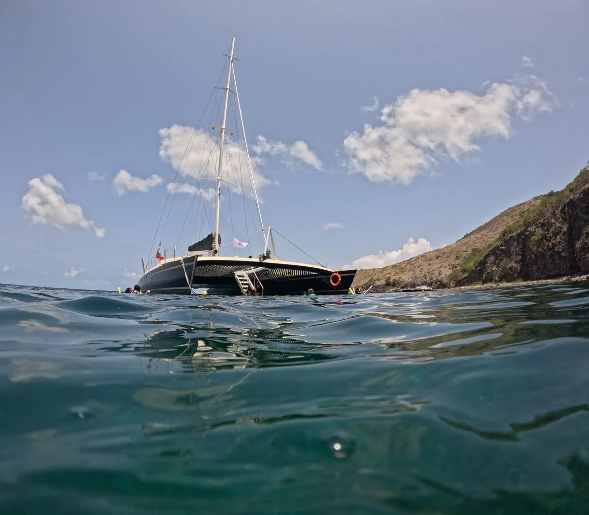 Catamaran anchored in clear Caribbean water during a snorkeling stop between St. Kitts and Nevis.
