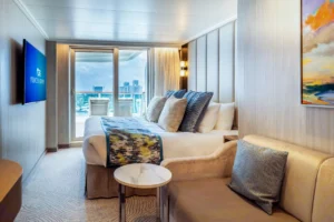 Princess Cruises balcony cabin with bed, sofa, and sliding doors opening to a private balcony.