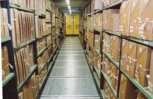 Rows of archival document boxes on shelving at The National Archives in Kew.