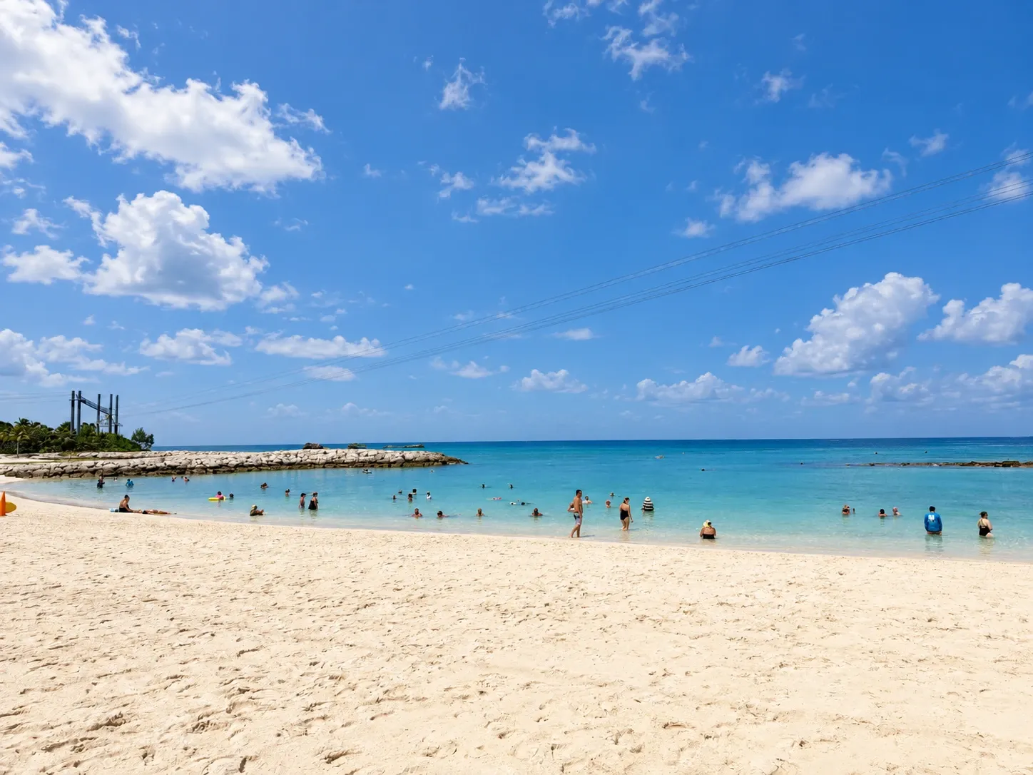 A sandy beach and calm turquoise water at Great Stirrup Cay under sunny blue skies.