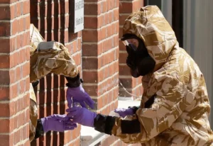 Specialist team members in military protective suits and purple gloves during Novichok cleanup operations in Salisbury.