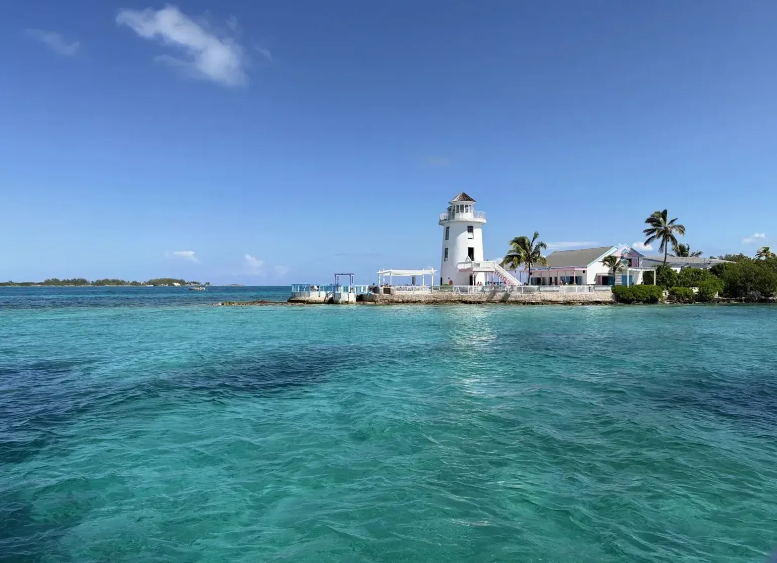 The white lighthouse at Pearl Island above clear turquoise water.