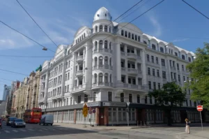 Stūra māja, Riga’s former KGB headquarters, on a sunny street corner beneath overhead wires.