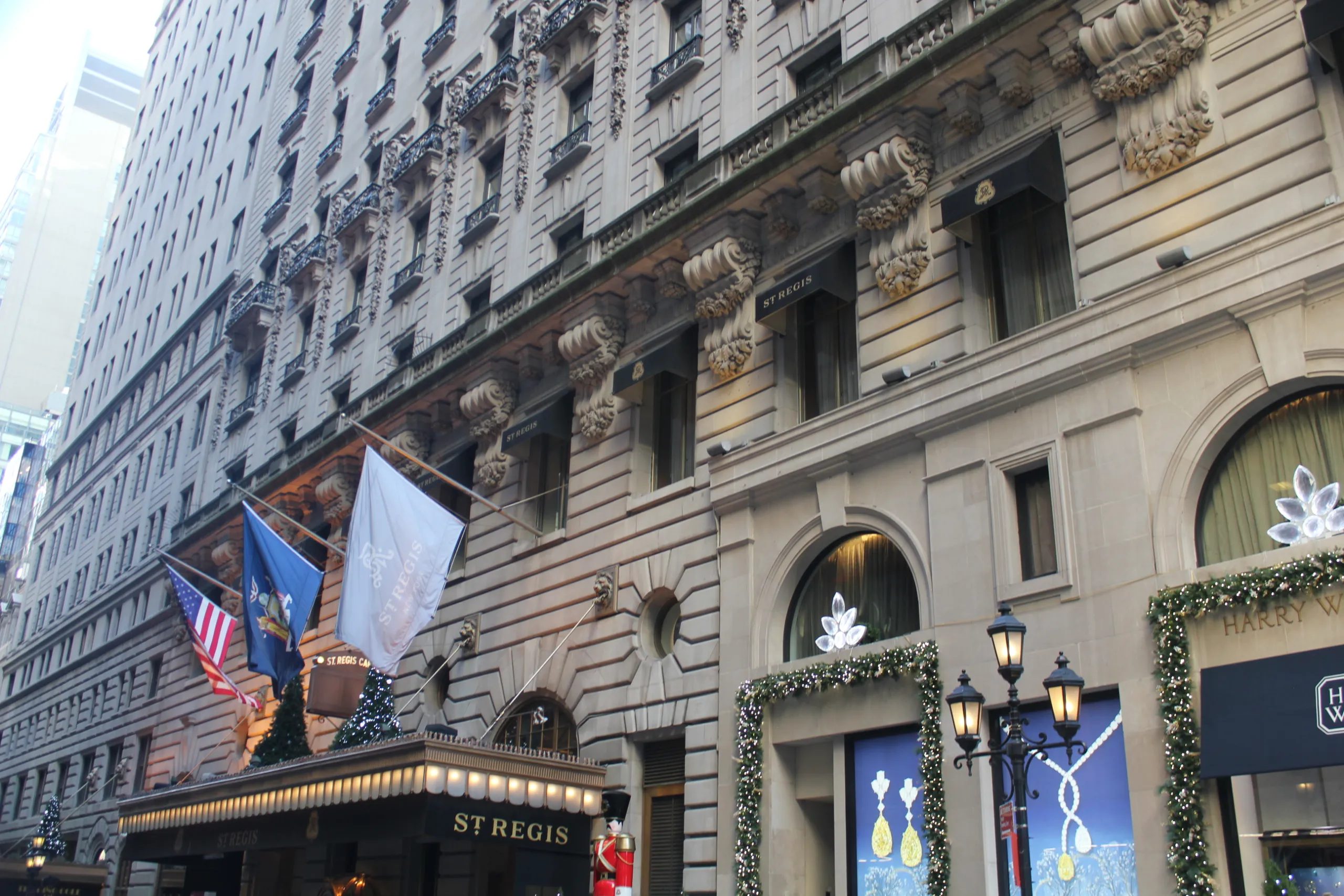 Ornate stone facade, flags and entrance canopy of The St. Regis New York on 55th Street.